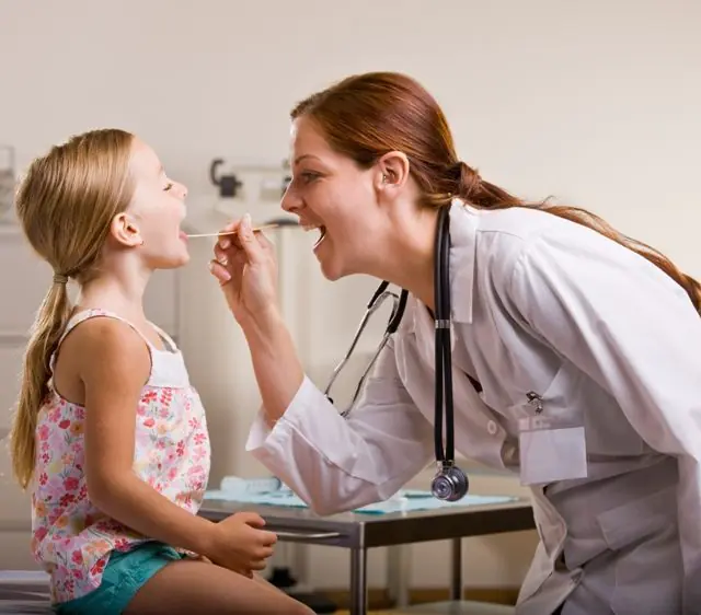 Visueel onderzoek van de keel van een kind door een KNO-arts