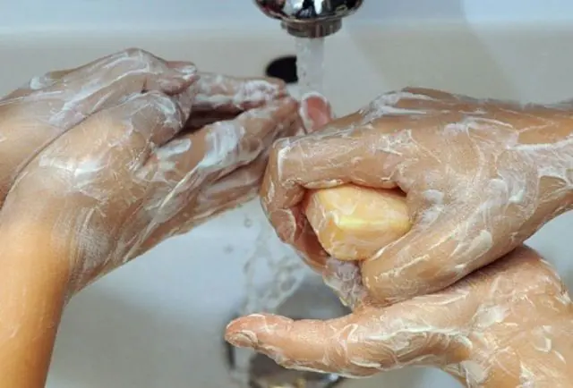 Folk vasker deres hænder med vaskesæbe